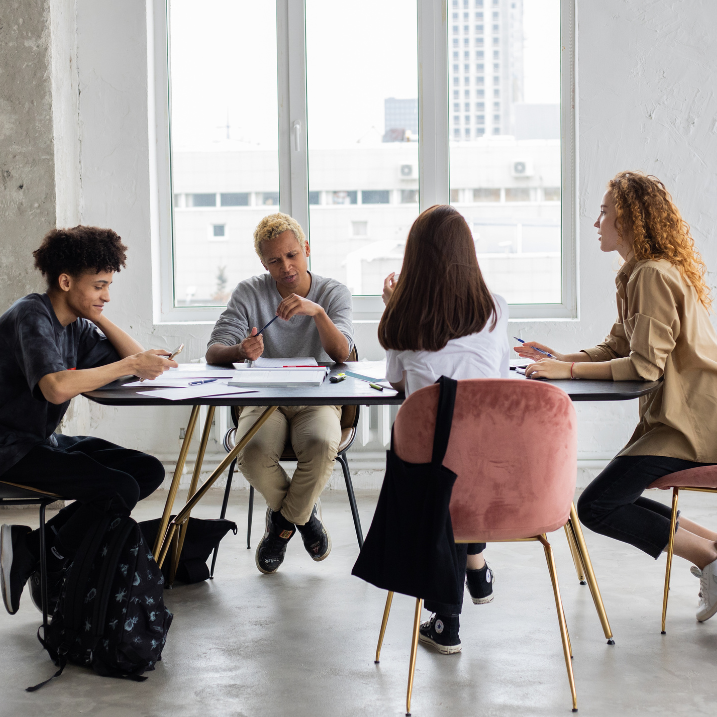 Four people sitting at a conference table in a modern office setting.