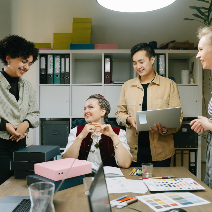 Group of people in a casual office setting, engaged in conversation.