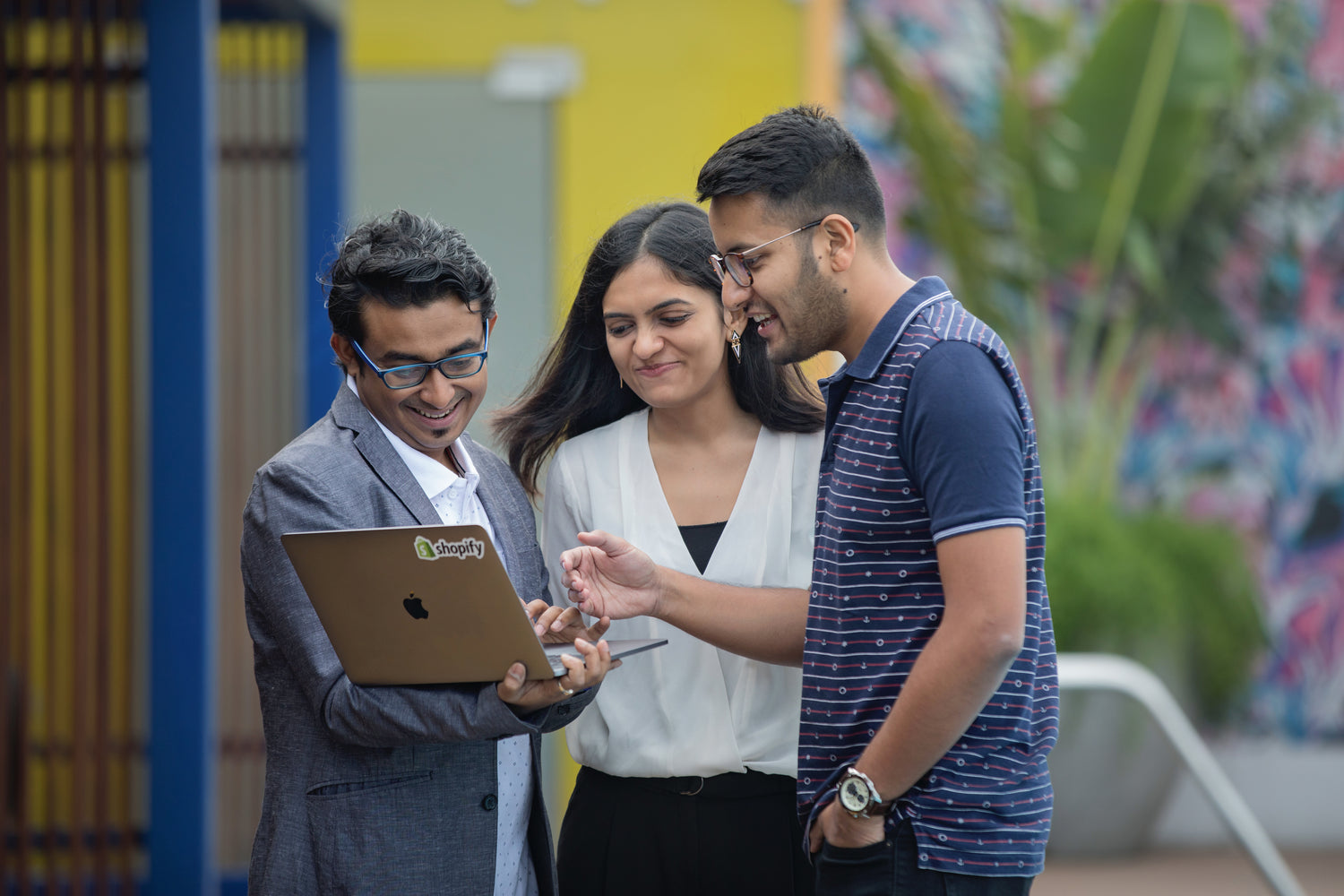 Three coworkers working on a laptop